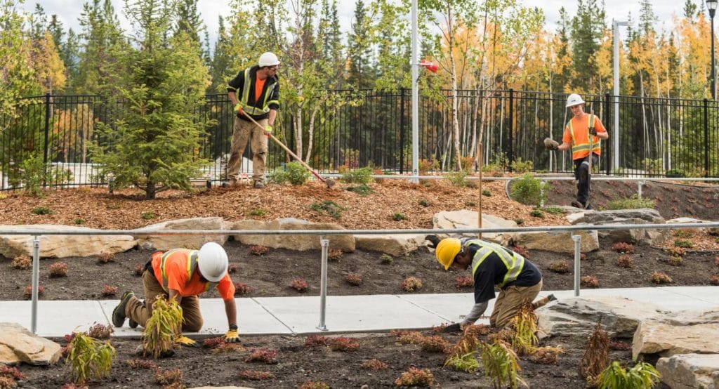 Lyons Landscaping crew preparing garden beds and mulch for spring property maintenance in Kamloops