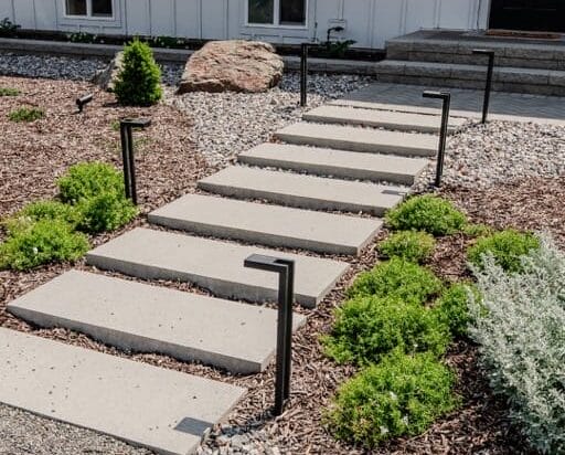 Strata landscaping in Kamloops BC with concrete walkway, drought-tolerant plants, and gravel design for hot Interior climate